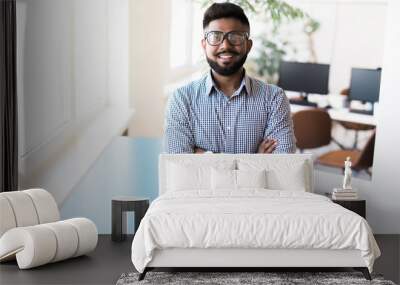 Happy indian business man standing in modern office Wall mural